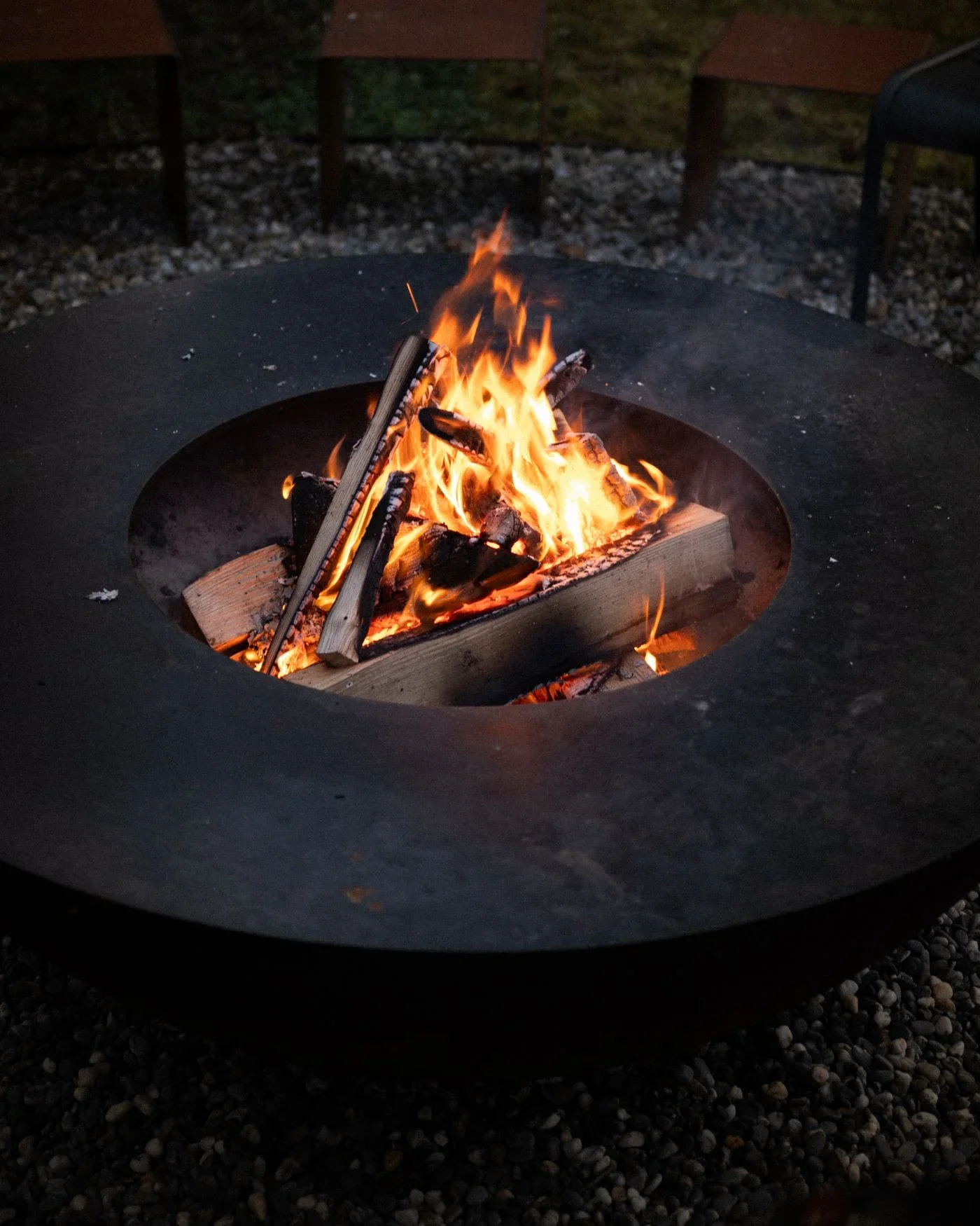 Round outdoor fire pit burning at night